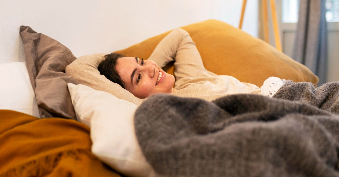 Cozy autumn bedroom with a soft mattress, warm blankets, and gentle evening light.