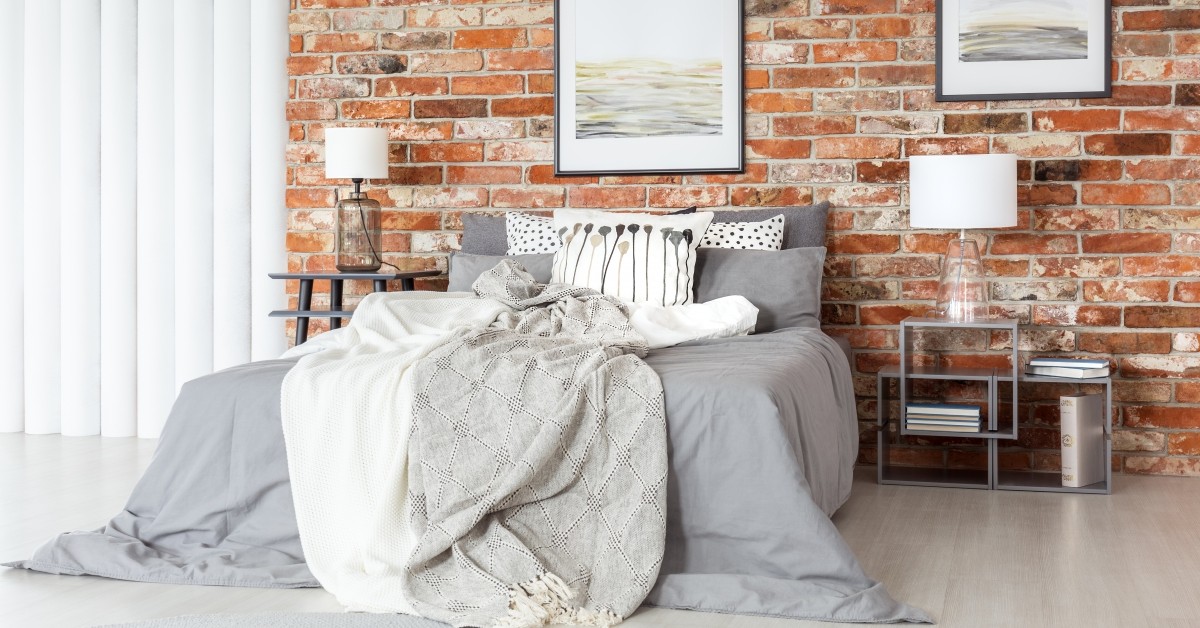 Image of modern bed with brick background.